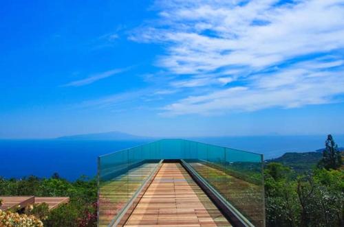 a glass walkway with a blue sky in the background at 伊豆高原 温泉付別荘 ISANA Mountain Villa - BBQ, Pizza Oven & Hotsprings in Futo