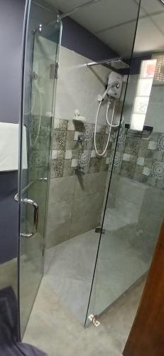 a shower with a glass door in a bathroom at Surf Side Komari in Arugam Bay