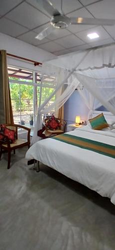 a bedroom with a large white bed and a window at Surf Side Komari in Arugam Bay