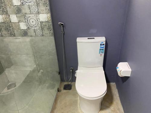a bathroom with a toilet and a shower at Surf Side Komari in Arugam Bay