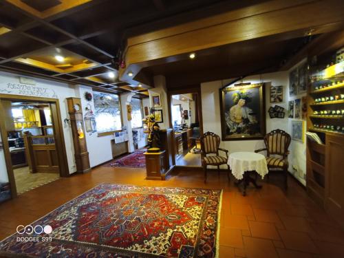 a room with a table and chairs and a rug at Park Hotel Arnica in Falcade