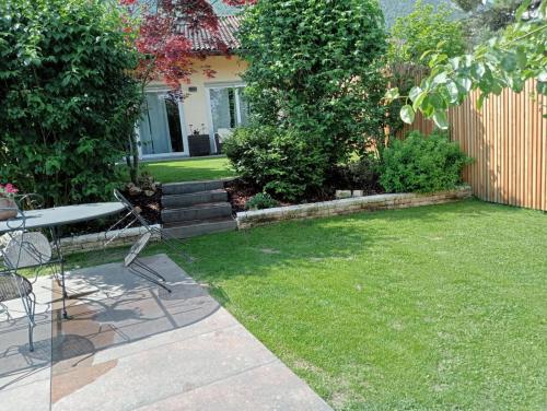 a garden with a table and chairs in a yard at Relax in Pineta in Caldonazzo