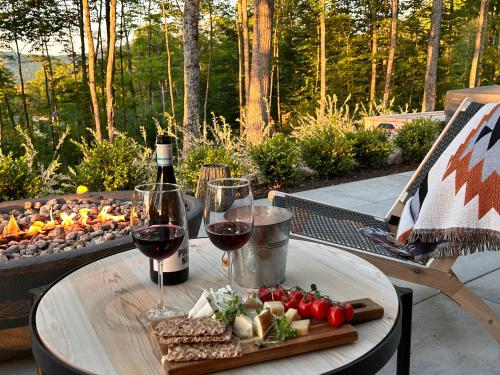 a table with two glasses of wine and a tray of food at Luxury Mountain Retreat with Spa Near Mont Tremblant in La Conception