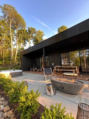 a black building with a large planter in front of it at Luxury Mountain Retreat with Spa Near Mont Tremblant in La Conception