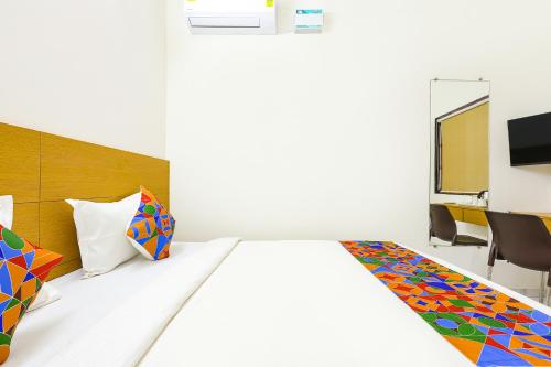 a bedroom with a bed and a desk with a tv at Pednekar Plaza Inn in Baga