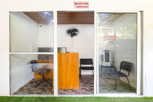 a sliding glass door of a room with a table and chairs at Pednekar Plaza Inn in Baga