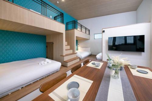 a bedroom with a bunk bed and a desk with a table at T-home彩 in Tokyo