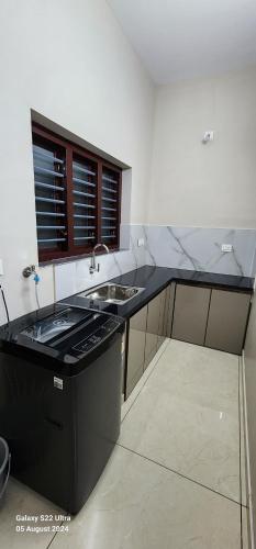a kitchen with a black counter and a sink at Nambiaparambil Arcade in Kakkayam
