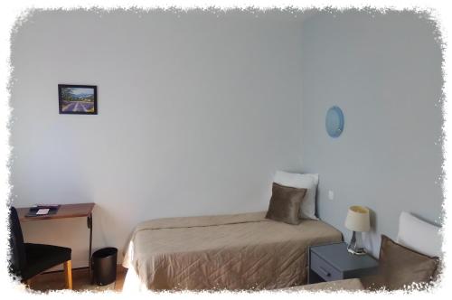 a bedroom with a bed and a table and a chair at Hotel Du Lac in Château-Arnoux-Saint-Auban