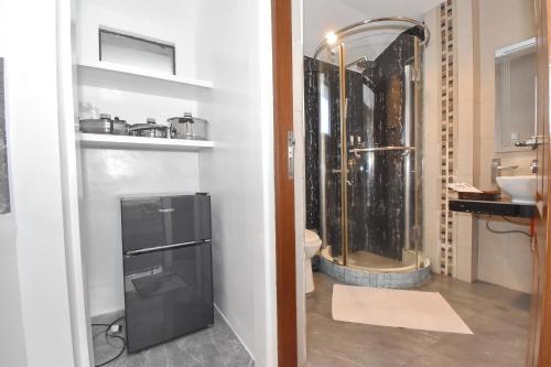 a bathroom with a shower and a sink and a refrigerator at Villa Sunset Boracay in Boracay