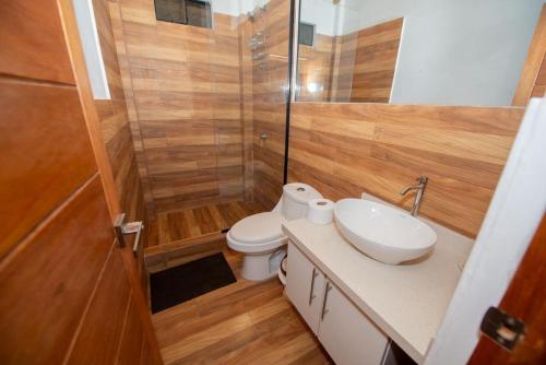 a bathroom with a toilet and a shower and a sink at Hermosa Casa con Piscina y Playa Privada in San Martín
