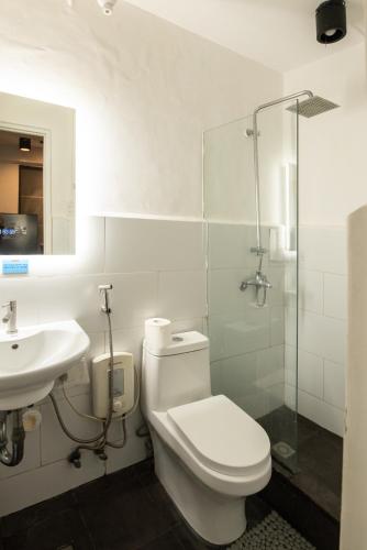 a bathroom with a toilet and a sink and a shower at Homey and Cozey Poblacion Makati S01 in Manila