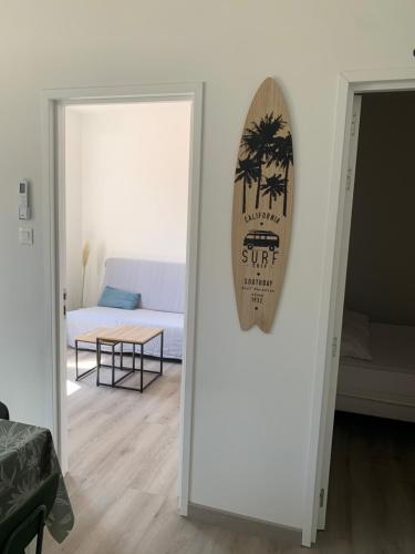 une porte vers un salon avec un panneau sur le mur dans l'établissement Maison de pécheur, à Saint-Elme