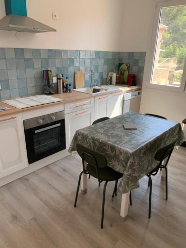 - une cuisine avec une table, des chaises et un évier dans l'établissement Maison de pécheur, à Saint-Elme