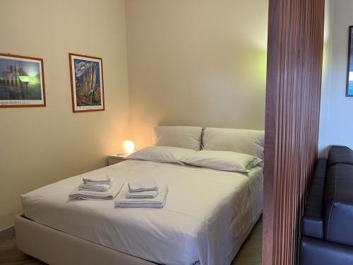 a bedroom with a bed with towels on it at Suite Laghetto EUR in Rome