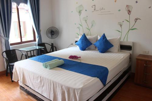 sypialnia z dużym łóżkiem i niebieskimi poduszkami w obiekcie Khai Yen Tam Coc Hostel w mieście Ninh Binh