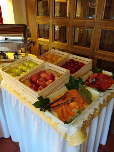 a table with boxes of fruits and vegetables on it at Park Hotel Arnica in Falcade
