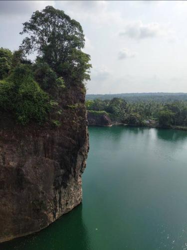 a large body of water next to a large cliff at River Heart Homestay in Aranmūla