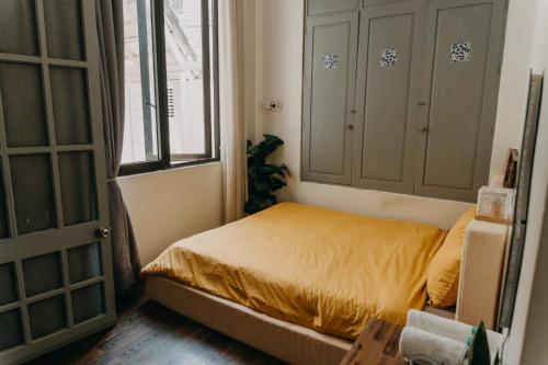 Un dormitorio pequeño con una cama y una ventana. en Nhà Bơ Homestay, en Phan Rang