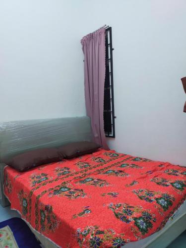a bedroom with a red bed with a window at Homestay Padang Kala in Kampong Pangkal Pisang