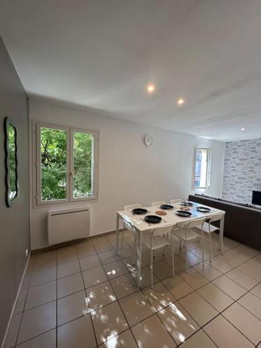 un salon avec une table et une fenêtre dans l'établissement L'Adrien Hébrard parking facile, à Grisolles