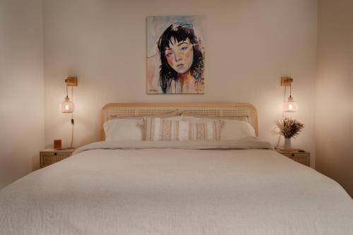 a bedroom with a white bed with a painting on the wall at Pulaski Point Properties in Chicago