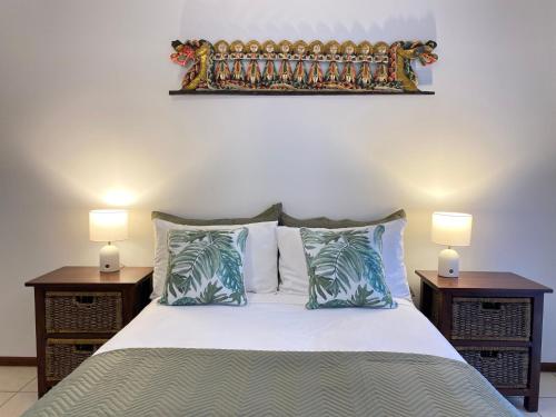 Un dormitorio con una cama con dos mesitas de noche y dos lámparas. en Banyak Villa, en Horseshoe Bay