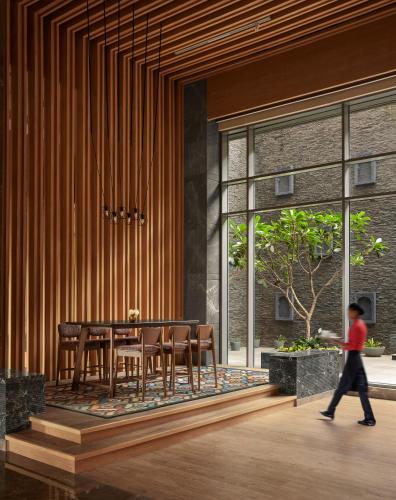 a child walks past a dining room with a table and chairs at Hyatt Place Aurangabad Airport in Aurangabad