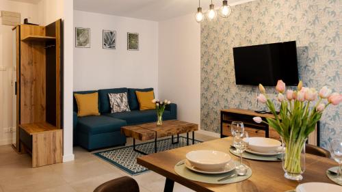 a living room with a blue couch and a table at Na Wydmie, Sun & Snow in Ustka