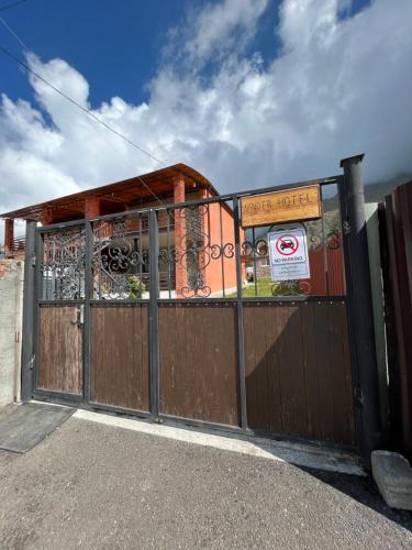 a gate in front of a building with a no parking sign at Wander Kazbegi Hotel in Stepantsminda