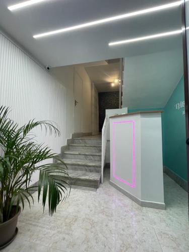 a hallway with stairs and a purple door and a plant at The green leaves in Santa Maria La Carità
