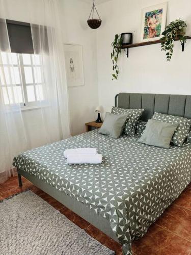 a bedroom with a bed with a gray and white comforter at La Casa de Eloisa in Santa Cruz de Tenerife