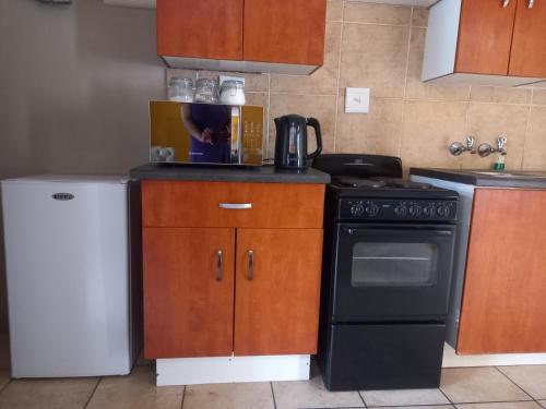a kitchen with a black stove and a refrigerator at Platinum gem in the City of Rustenburg in Rustenburg
