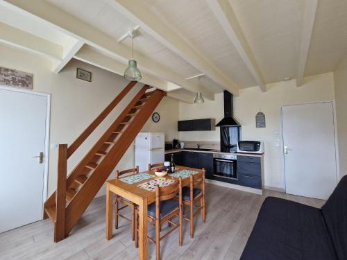- une cuisine et une salle à manger avec une table en bois et des escaliers dans l'établissement Cottage in France near Côte du Goëlo, à Plérin