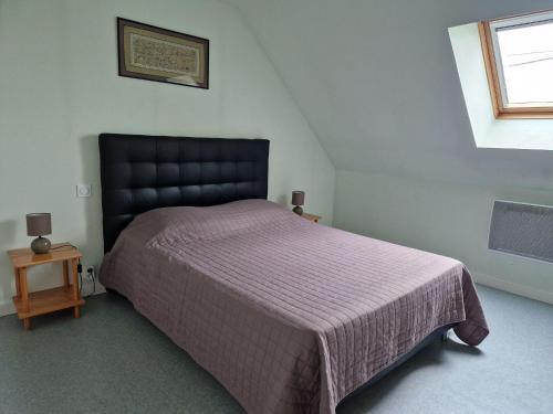 une chambre avec un grand lit avec une couverture violette dans l'établissement Cottage in France near Côte du Goëlo, à Plérin