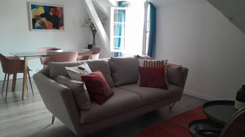 - un salon avec un canapé et des oreillers dans l'établissement ALEIDA, à La Rochelle