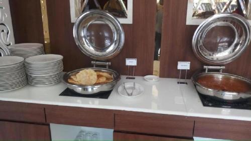 un comptoir avec deux bols et assiettes et un bol de pain dans l'établissement AGM GRAND HOTEL & Spa, à Digha