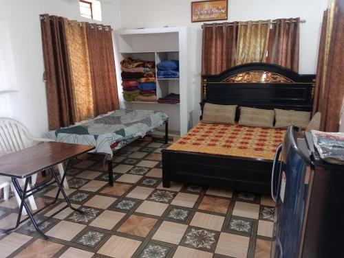 Habitación pequeña con cama, mesa y sidra de mesa en Shivraj farms, en Bedla