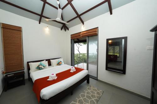 a bedroom with a bed and a ceiling fan at Bougain Villa Resort Park By Dream Villas in Pune