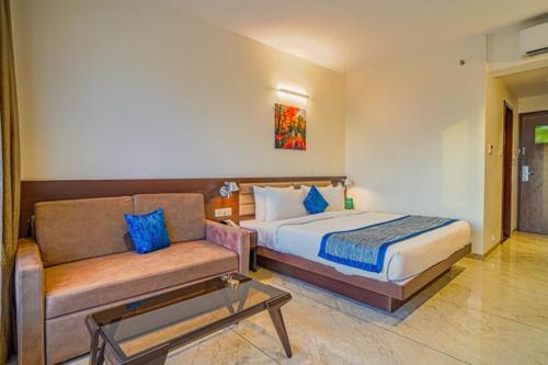 a bedroom with a bed and a couch at The Fern Sardar Sarovar Resort Kevadia, Gujarat in Kevadia