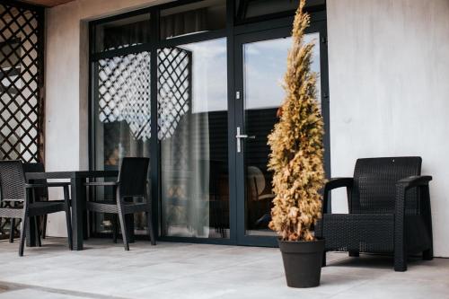 a patio with chairs and a table and a plant at Daroszówka - Domki i Apartamenty z Widokiem Solina in Solina