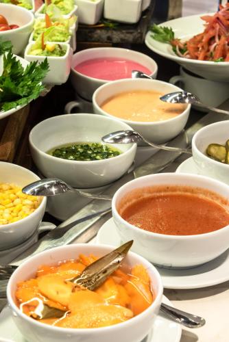 a table with bowls of soup and other bowls of food at Okash City Boutique Hotel in Nairobi