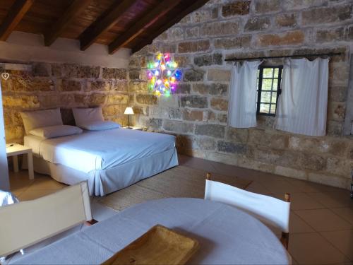 a bedroom with two beds and a stone wall at Casetta vacanza in campagna in Aradeo