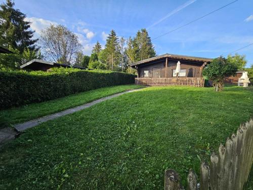 a yard with a house in the background with a fence at Ferienhaus Waldgefluester in Nausis