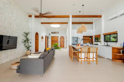 ein Wohnzimmer und eine Küche mit einer Couch und einem Tisch in der Unterkunft Sitaya Beachfront Villas, Koh Phangan in Ko Phangan