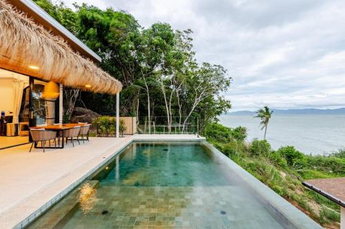 ein Swimmingpool mit Blick auf das Meer in der Unterkunft Sitaya Beachfront Villas, Koh Phangan in Ko Phangan
