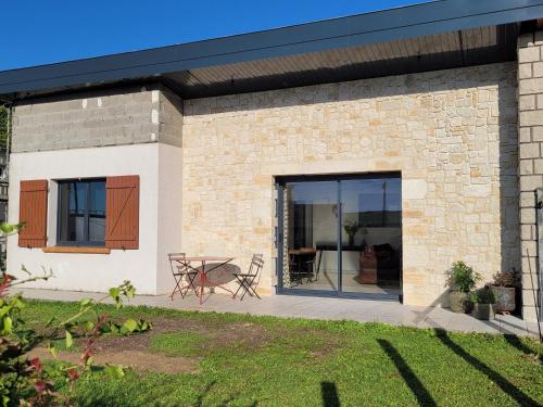 a brick house with a patio and a table at 2 Gites dans les remparts à Dun sur Meuse in Dun-sur-Meuse