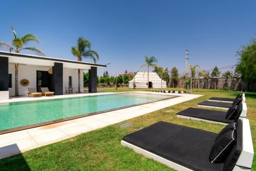 a pool with several yoga mats next to a house at Villatina suite RABAT in El Aggada