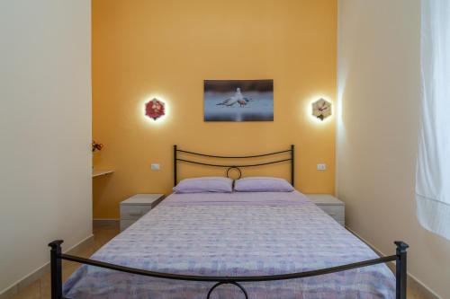 una camera da letto con un letto in una stanza di Il cappello sulle 23 ad Avola