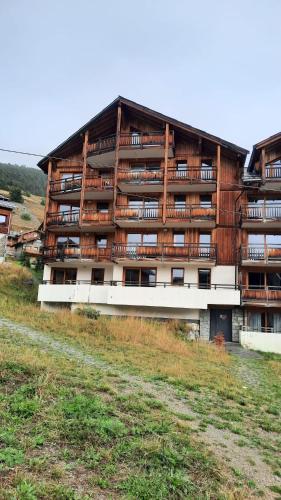 un grand bâtiment avec des balcons sur le côté dans l'établissement Le Cocon des Airelles - Meublé de tourisme 3 étoiles au pied des pistes avec garage, à Montgenèvre